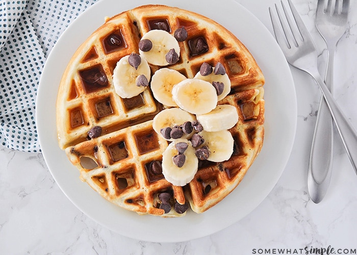 a homemade chocolate chip waffle topped with bananas and chocolate chips