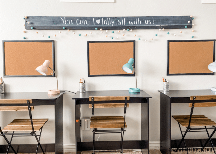 desks against the wall with corkboards and a chalkboard