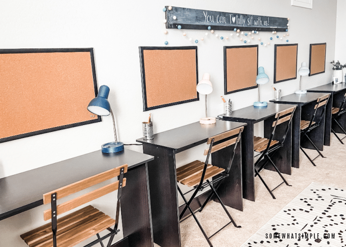 row of desks with cork boards above each one
